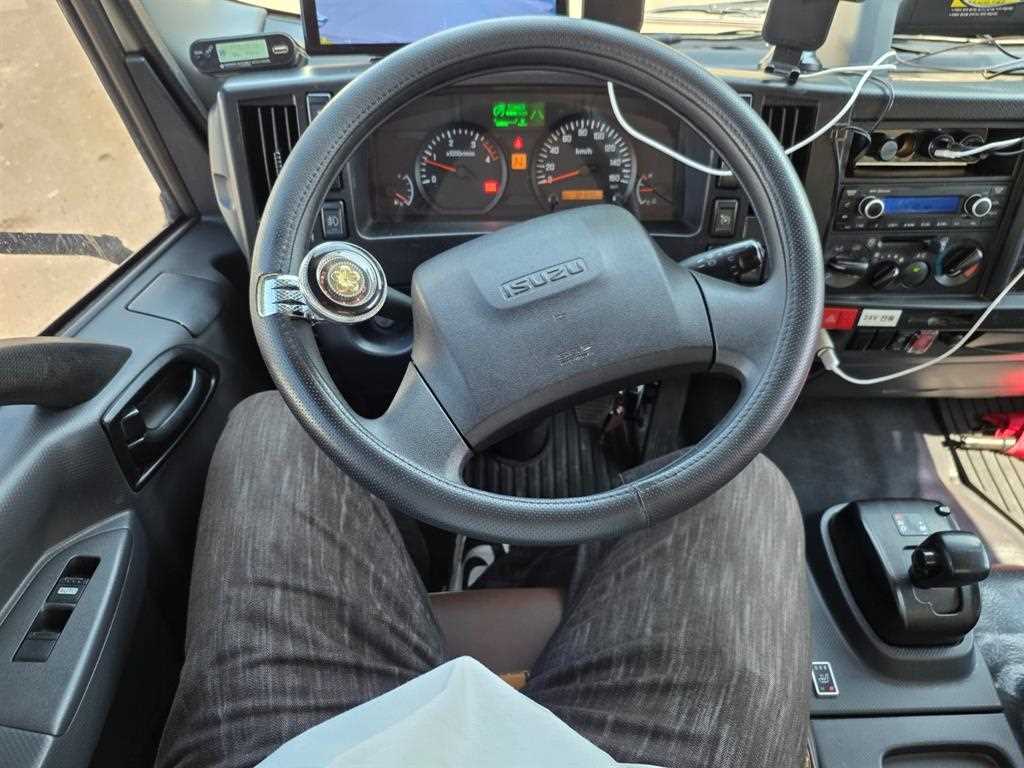 이스즈 엘프 3.5톤 윙바디 2024년식 운전석: ISUZU 핸들과 바늘식 계기판